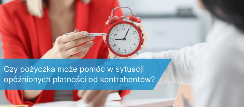 Kobieta w czerwonym żakiecie podaje długopis drugiej osobie trzymającej czerwony budzik